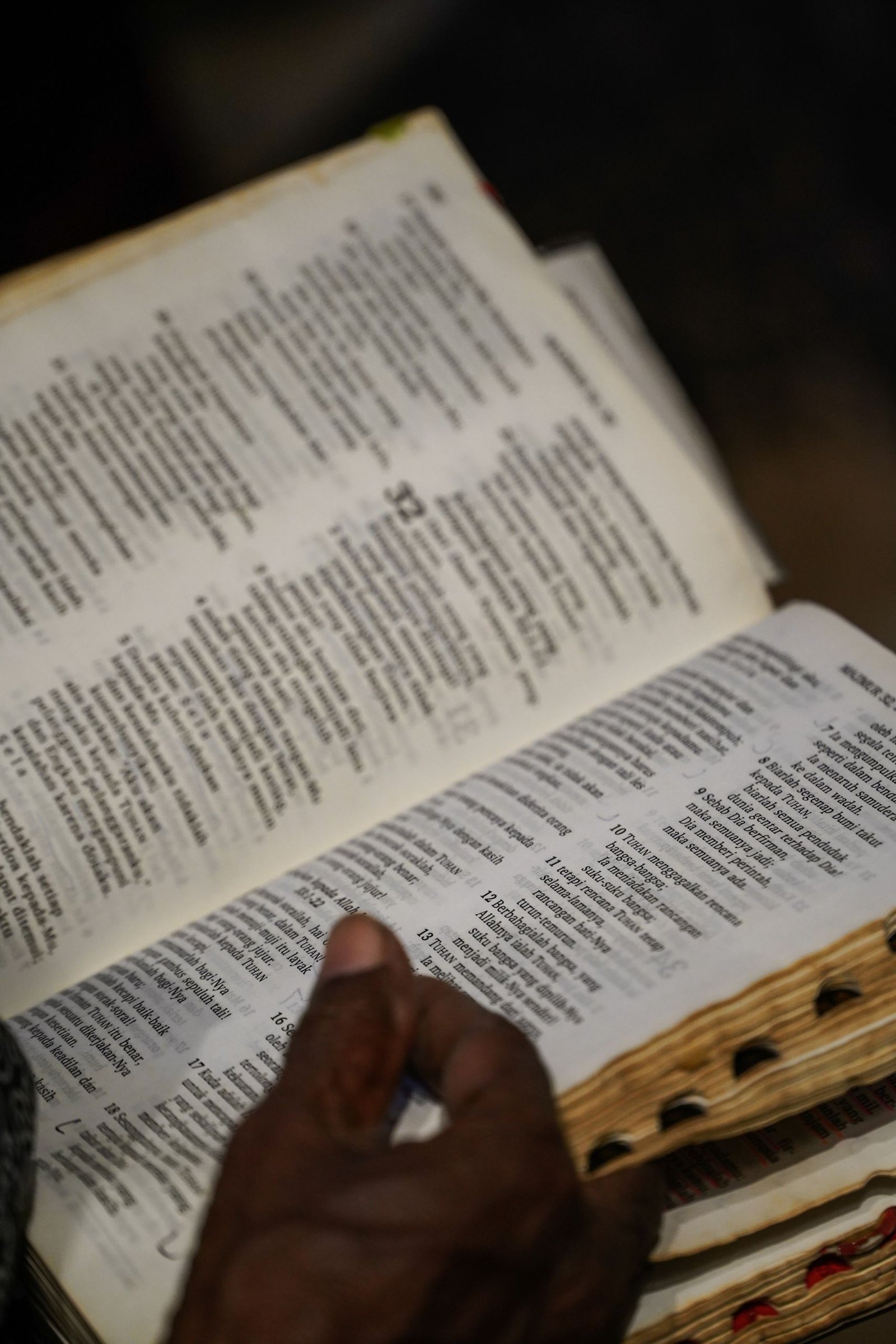 Close-up of a person engaging in Bible study, with focus on an open page.
