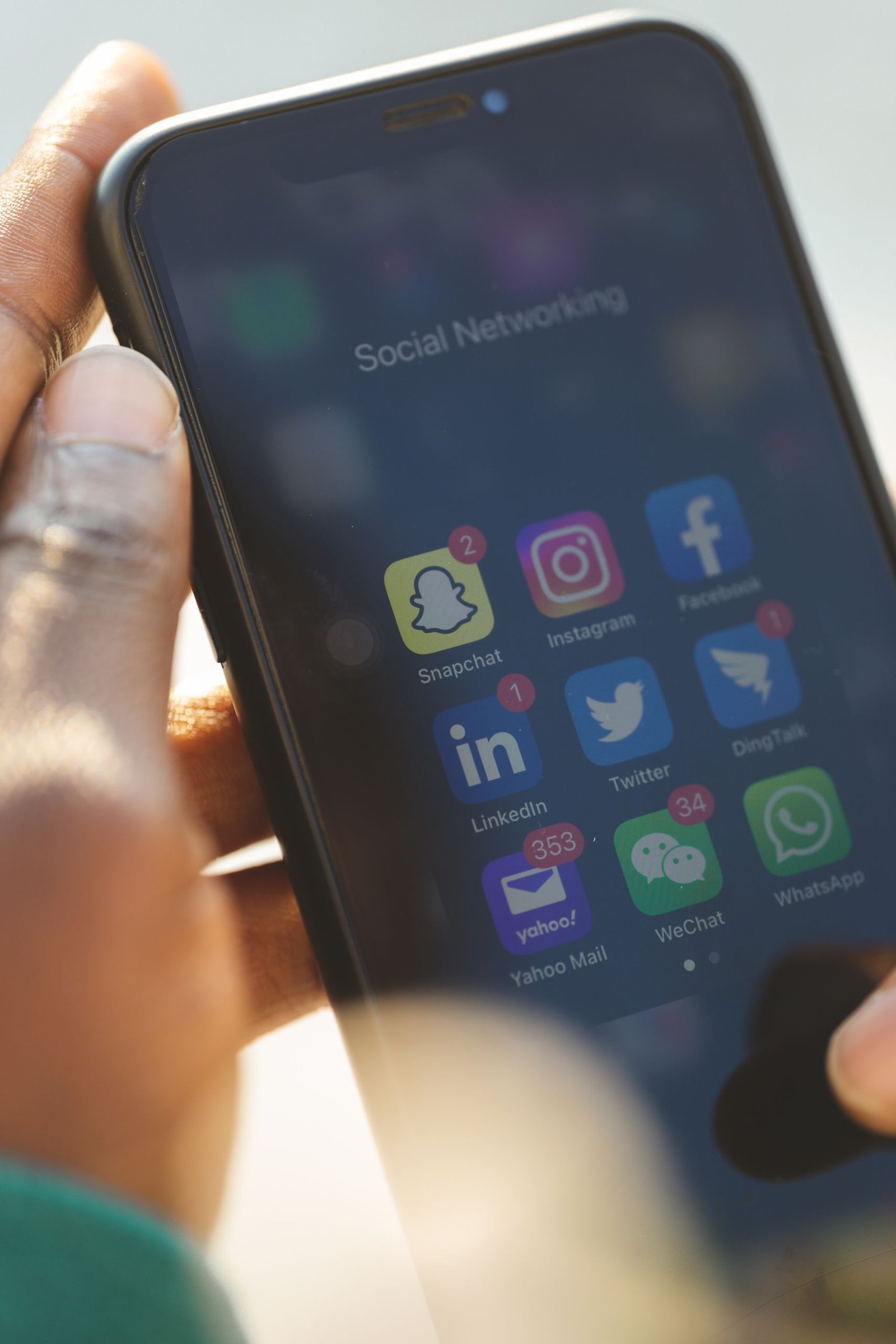 Close-up of a smartphone showing various social media applications being used.